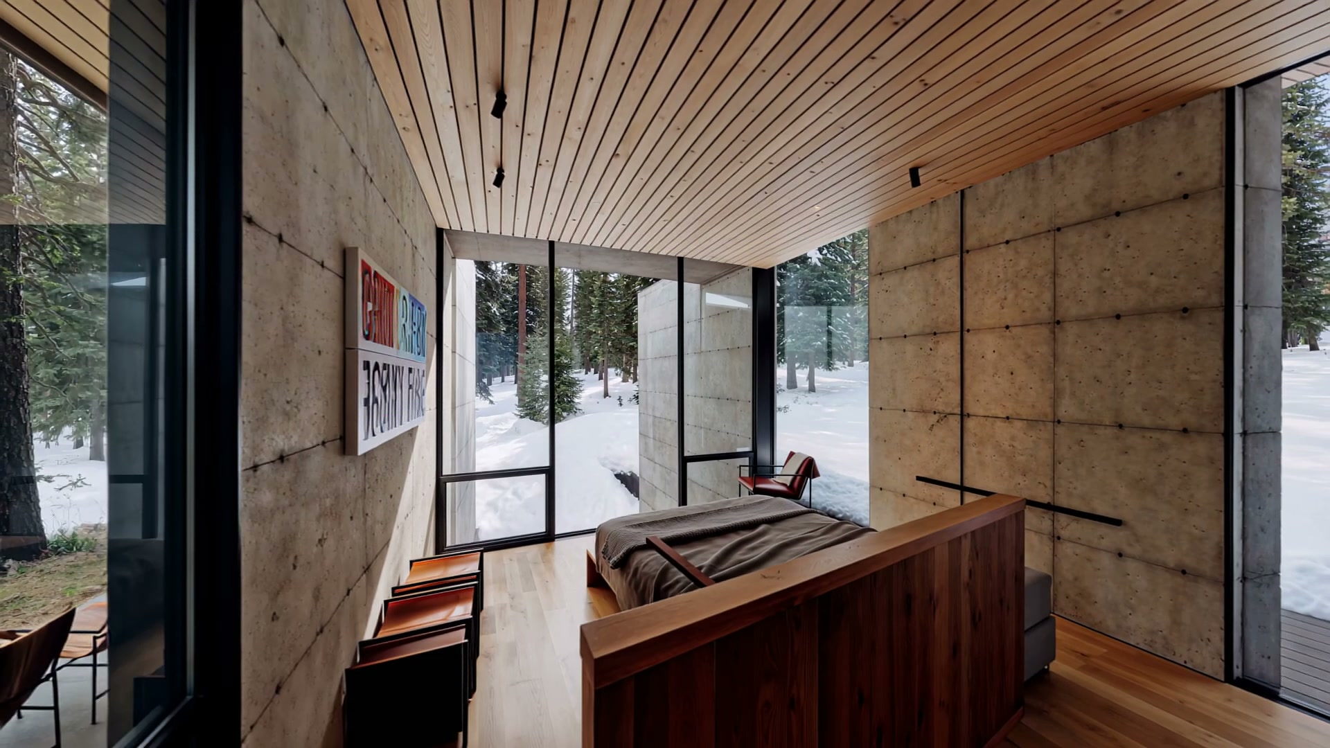 Bedroom with snowy forest framed by floor-to-ceiling glass